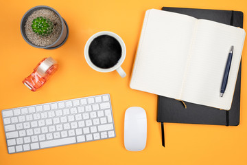 directly above shot of office workspace with computer keyboard, mouse, coffee mug, note pad and potted plant, home office and working from home concept