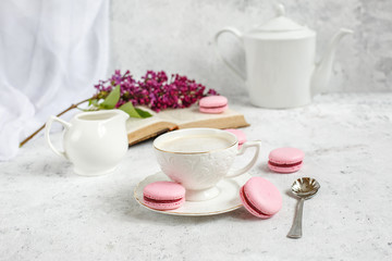 A Cup of morning coffee, a bowl of lilac, macaroni, on a light background. Postcard good morning