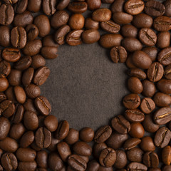 Frame of roasted coffee beans, in the middle a round copy space on black background
