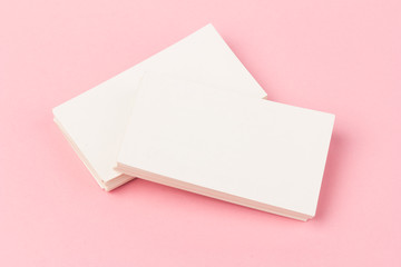 Obraz na płótnie Canvas white blank business cards on pink background in close-up