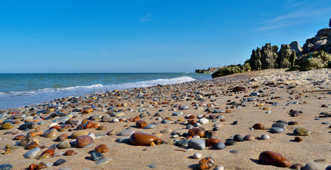 Fototapeta na wymiar Colored pebbles on a sandy beach. Blurred background.