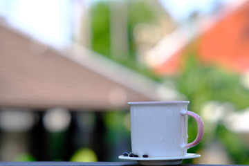 Coffee cup and coffee beans on wooden table background