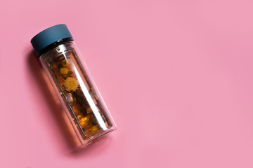 glass bottle with green tea on bright pink background, healthy lifestyle concept