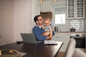 Obraz premium Father takes a break from work to play with his baby boy.