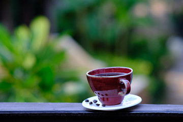 Coffee cup and coffee beans on wooden table background