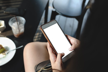 Close up of woman using cell phone sending massages  for shopping online within the cafe.having sunbath.Phone with black screen,texting,video calls.