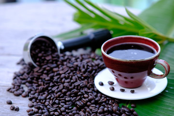 Coffee cup and coffee beans on wooden table background