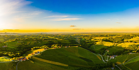 Gorgeous sunset over beautiful green vineyards. Aerial panorama sunset over Austrian grape hills in spring.