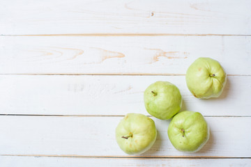 Guavas on white wooden table.