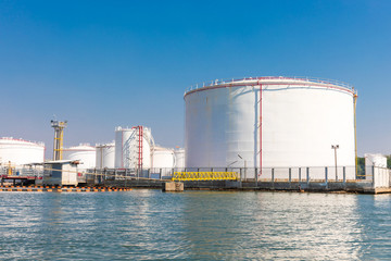 White fuel storage tank in an industrial area near the river