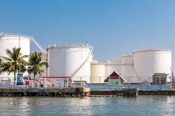Obraz premium White fuel storage tank in an industrial area near the river