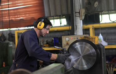Factory Engineer operating big machine cut off material for industry concept