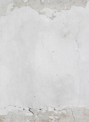 the background of the cracked white wall of the house is old covered with plaster and the paint is peeling from time. Very old house. cracks in the wall