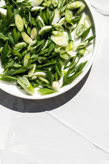 Photo of colorful fresh organic vegetables radish, cucumber, green onion concept on white background sunlight