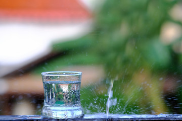 Close up pouring purified fresh drink water from the bottle on wood counter and space for text