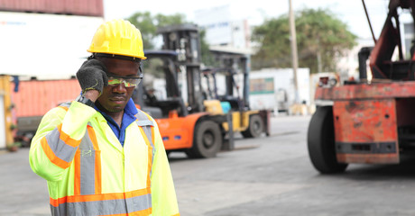 Fototapeta na wymiar Close up of An African American handsome black engineer he is working in container box yard area