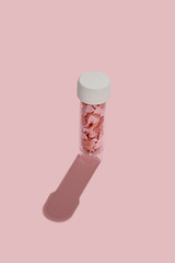 Love pills heart pills concept. transparent case for pills with heart shape pills in it on pink background