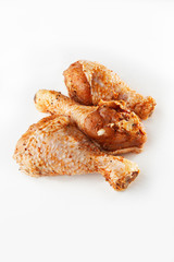 Raw drumsticks on white background. Chicken legs. Raw chicken marinated legs. Top view. Food...