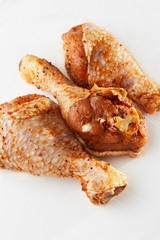 Raw drumsticks on white background. Chicken legs. Raw chicken marinated legs. Top view. Food Background. Cooking content. Uncooked meat. Meat shop concept.