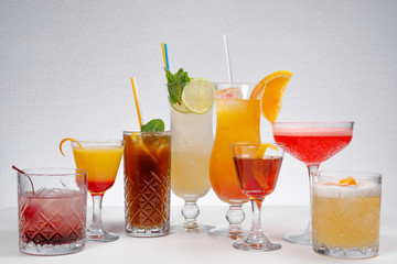 Glasses of tasty summer cocktails on white background