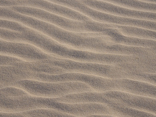 Closeup of yellow sand pattern of a beach in the summer. 