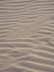 Closeup of yellow sand pattern of a beach in the summer. 