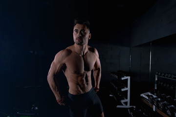 Fototapeta na wymiar male athlete flaunts his athletic body in the gym, sexy guy bodybuilder, sports lifestyle, home sports.