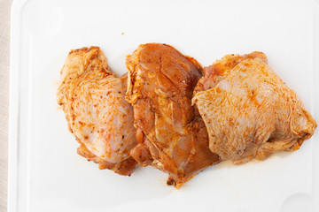 Free range Boneless chicken thighs on stone table. Raw chicken marinated thigh . The view from the...