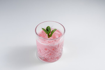 Glass with tasty pink cocktail on a white background