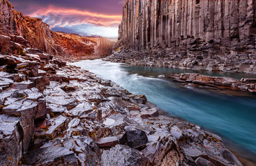  Wonderful Nature landscape. Incredible view on river in canyon with black basalt columns  under sunlight, Tipical Icelandic scenery. Studlagil Canyon during sunset. Iconic location for photographers.