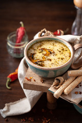cream soup with mushrooms in a beautiful serving with bread sticks