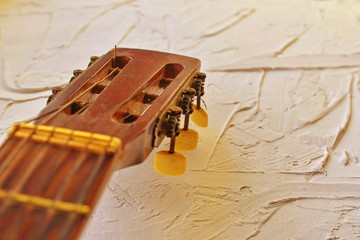 Old acoustic guitar head with tuning pegs. Copy space. Warm and vivid colors.