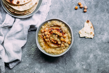 hummus in a plate on a table with corn tortillas