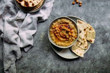 hummus in a plate on a table with corn tortillas
