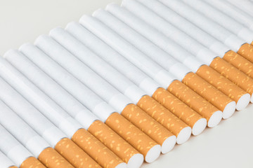 Long row of cigarettes with orange filter tips