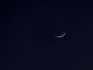 Obraz na płótnie Canvas The beautiful crescent moon shining in the dark night sky...