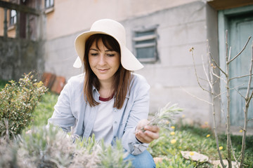 Lady sitting in garden and holding torn flowers