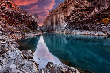  Wonderful Nature landscape. Incredible view on river in canyon with black basalt columns  under sunlight, Tipical Icelandic scenery. Studlagil Canyon during sunset. Iconic location for photographers.