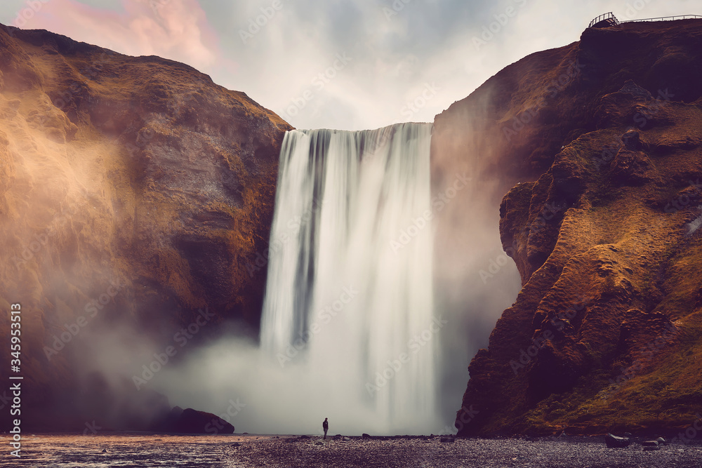 Fototapete Amazing Icelandic Landscape. Incredible view of famous Skogafoss waterfall during sunset. Dramatic Scenery of Iceland. Skogafoss Waterfall. Iceland the most beautiful and best travel place. postcard