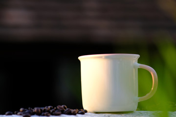 Coffee cup and coffee beans on wooden table background