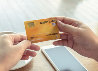 Woman holding credit card in coffee shop.