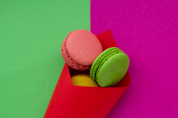 The cone with colorful macaron or macaroon on bright background. Top view.