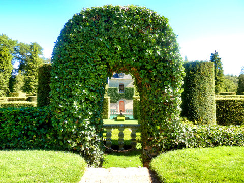 House Seen Through A Topiary Arch Of Virginia Creeper Found In Eyrignac Manor Garden, Dordogne, France