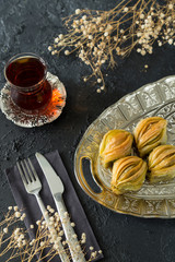 Mussel pistachio Baklava in the silver plate on the black background for food photo concept.