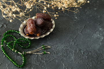 Dried date fruit or Hurma in the copper plate on the black background for Ramadan tables concept.