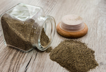 ground pepper in a glass jar on a wooden background.