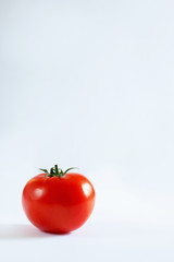 one red tomato on a white background
