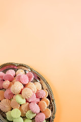 silver tray with meringues on a peach background
