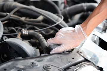 The mechanic is checking the engine condition of car.