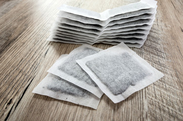 Tea bags on wooden background.